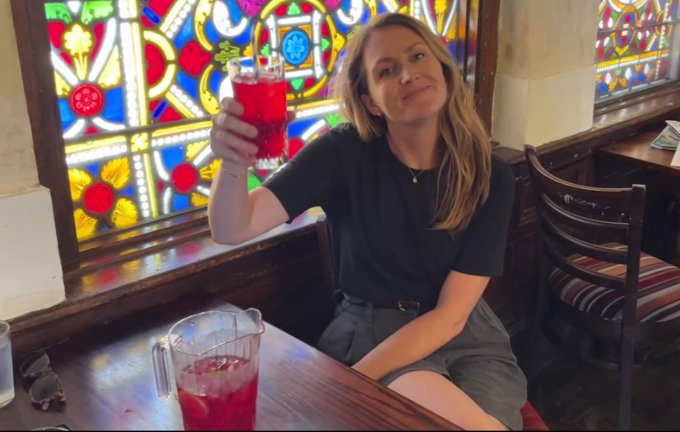 The Sun's Deputy Travel Editor Kara Godfrey enjoys a drink next to one of the stunning stained glass windows