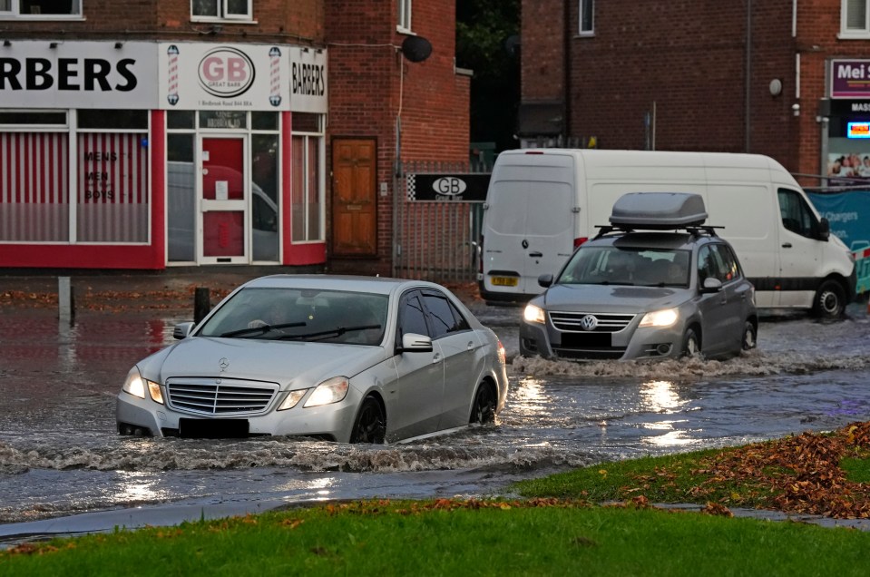 Motorists navigating through flood water in Perry Bar, Birmingham