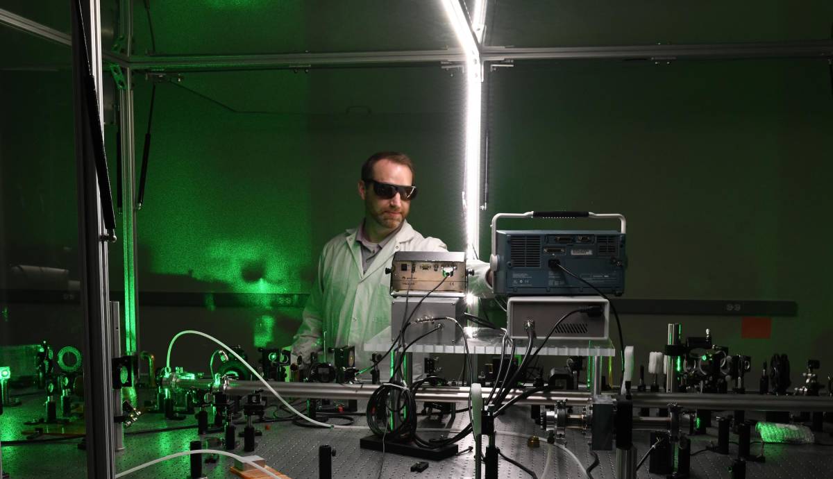 A scientist oversees a laser experiment.