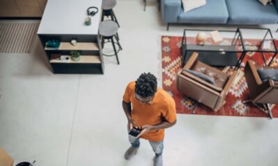 A man standing in modern apartment and using a smart phone