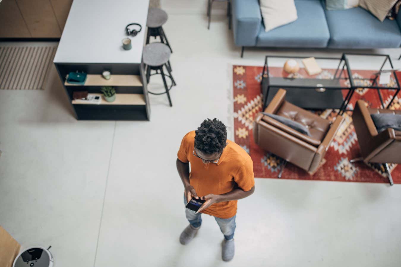 A man standing in modern apartment and using a smart phone