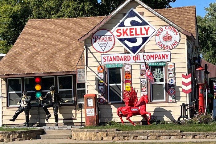 View of a wooden building with tiled roof with models of the Blues Brothers outside. River City Resale owned by Corey Gokey