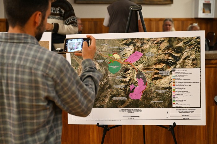 Person takes a photo of a display showing the lithium mine project details  in Tonopah, Nevada