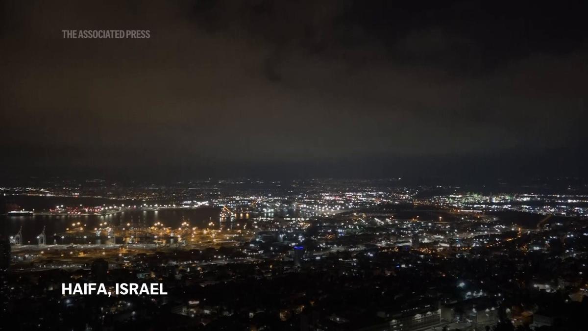 Security personnel clear rubble after sirens and blasts heard in Haifa, northern Israel