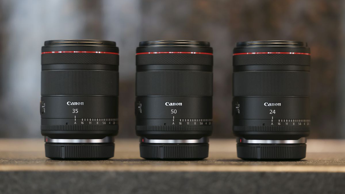 Canon RF 50mm F1.4L VCM and Canon RF 24mm F1.4L VCM lenses alongside the 35mm version on a rustic worktop