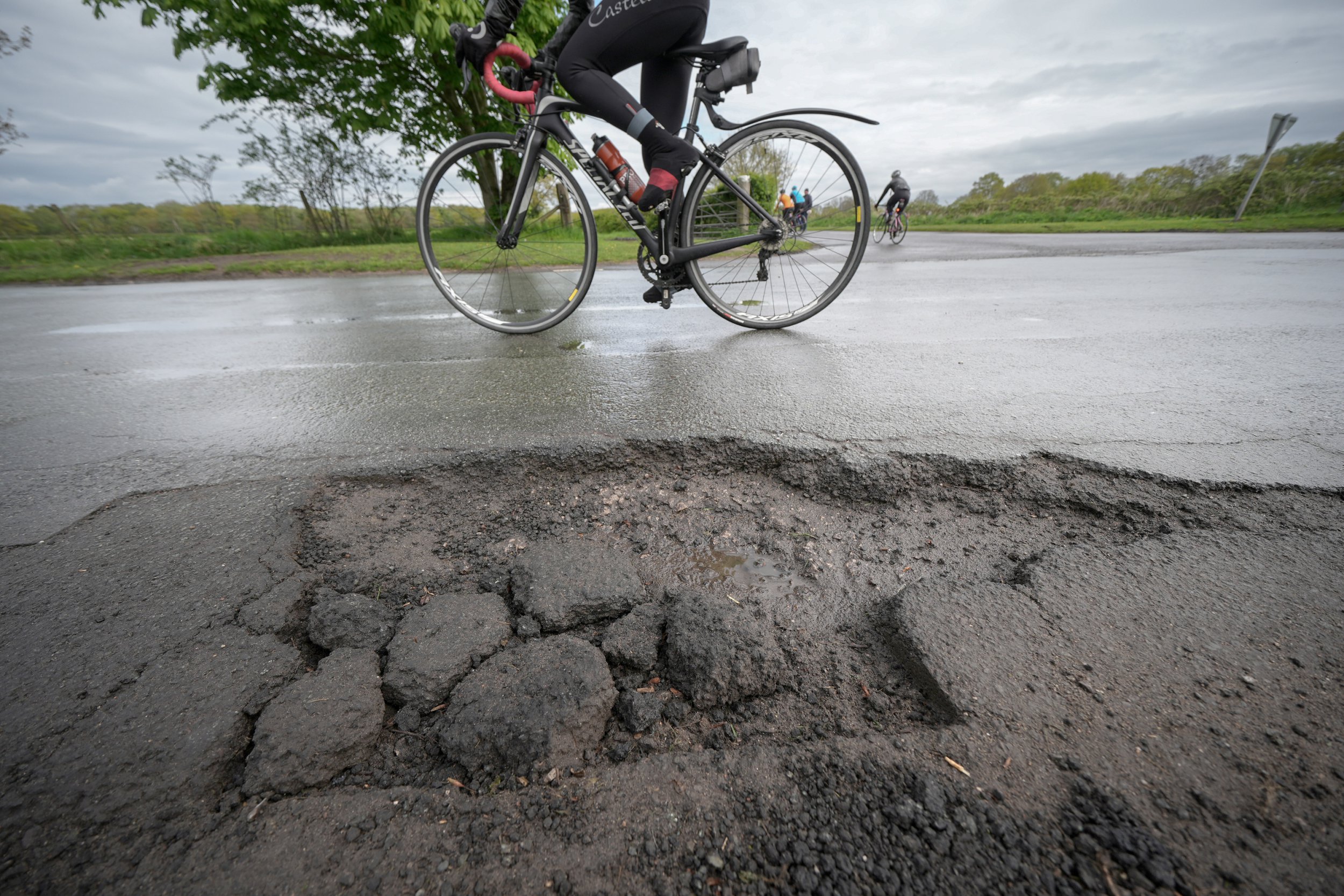 NORTHWICH, UNITED KINGDOM- APRIL 25: A cyclist rides past a pothole on the road on April 25, 2024 near Northwich, United Kingdom. The UK's roads have a large number of potholes due to high traffic levels and its cold and wet climate during winter. British motoring organisation, the RAC, says new figures show vehicle breakdowns rose by 9% in the last year due to potholes. (Photo by Christopher Furlong/Getty Images)