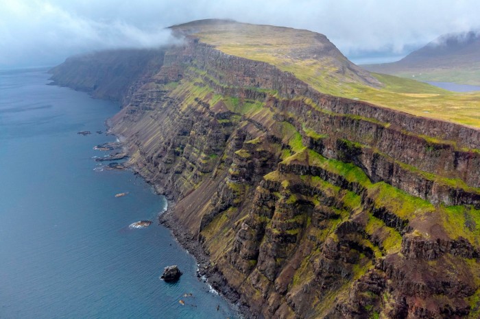 The table top of a mountain gives way to a sheer cliff dropping hundreds of metres to the ocean below