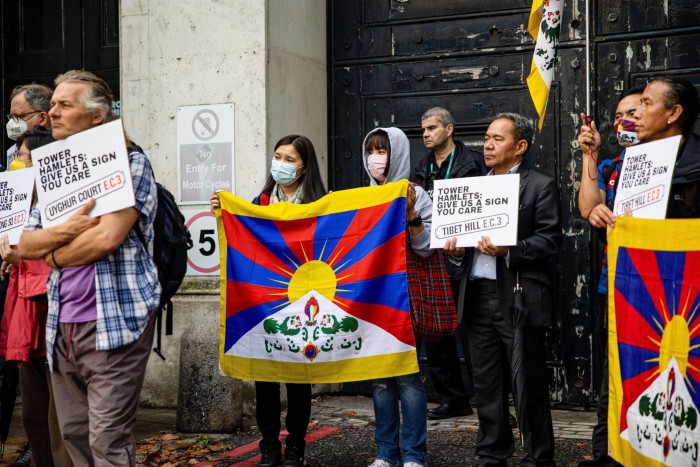 Protesters holding a Tibetan flag and placards at a demonstration  outside Royal Mint Court in September 2021