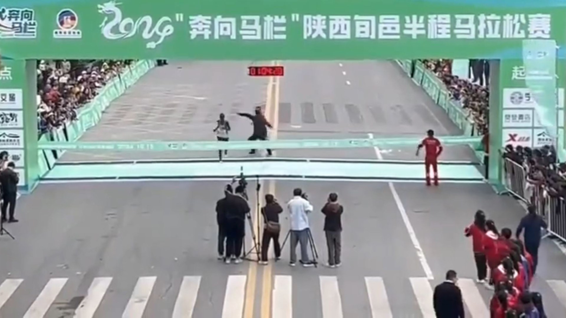 Watch hilarious moment fake marathon runner tries to cheat victory before being tackled by quick-thinking race official