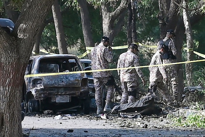 Security personnel inspect the site, a day after an explosion allegedly by separatist militants targeted a high-level convoy of Chinese engineers and investors near the Karachi international airport