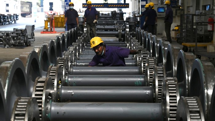 A worker checks wheel sets at the Integral Coach Factory in Chennai