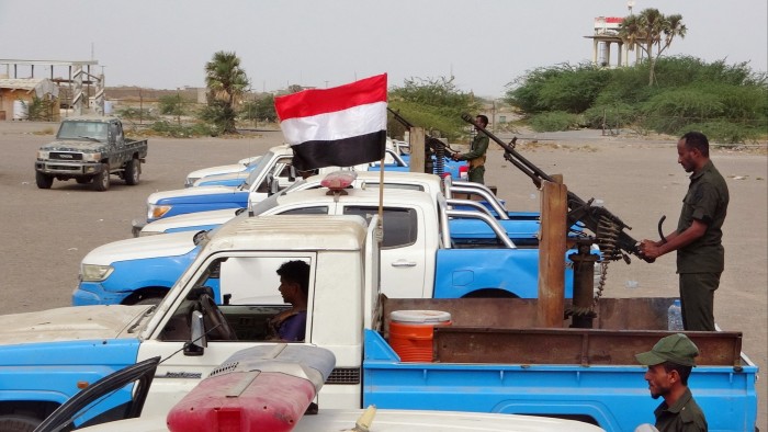 Soldiers standing on the back of trucks