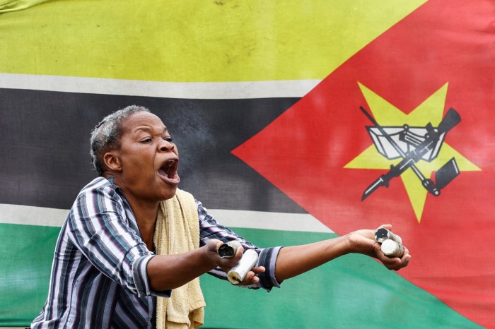 A woman reacts while holding used teargas cannisters after police officers fired at a crowd gathering during a “national shutdown” against the election outcome, at Luis Cabral township in Maputo, Mozambique