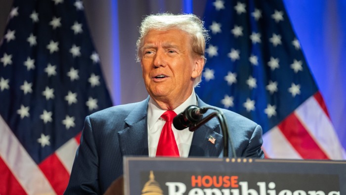 Donald Trump speaks on stage in front of US flags at a House Republicans Conference meeting on Capitol Hill on Wednesday