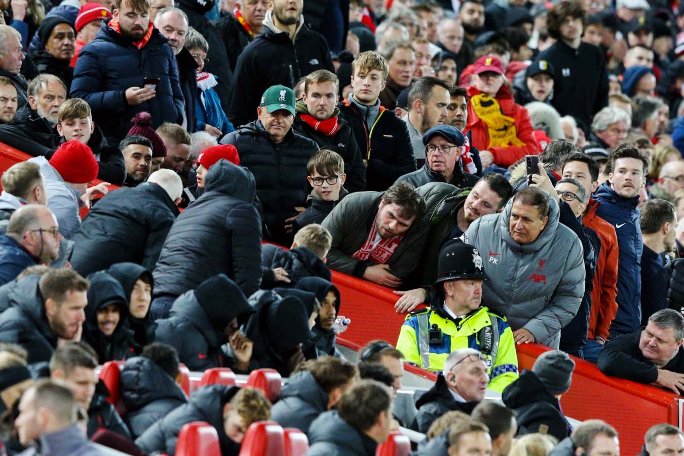 Liverpool fans jostle for a look at the on-field VAR screen at Anfield stadium