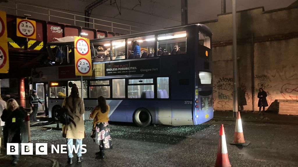 Roof torn off bus after crashing into railway bridge