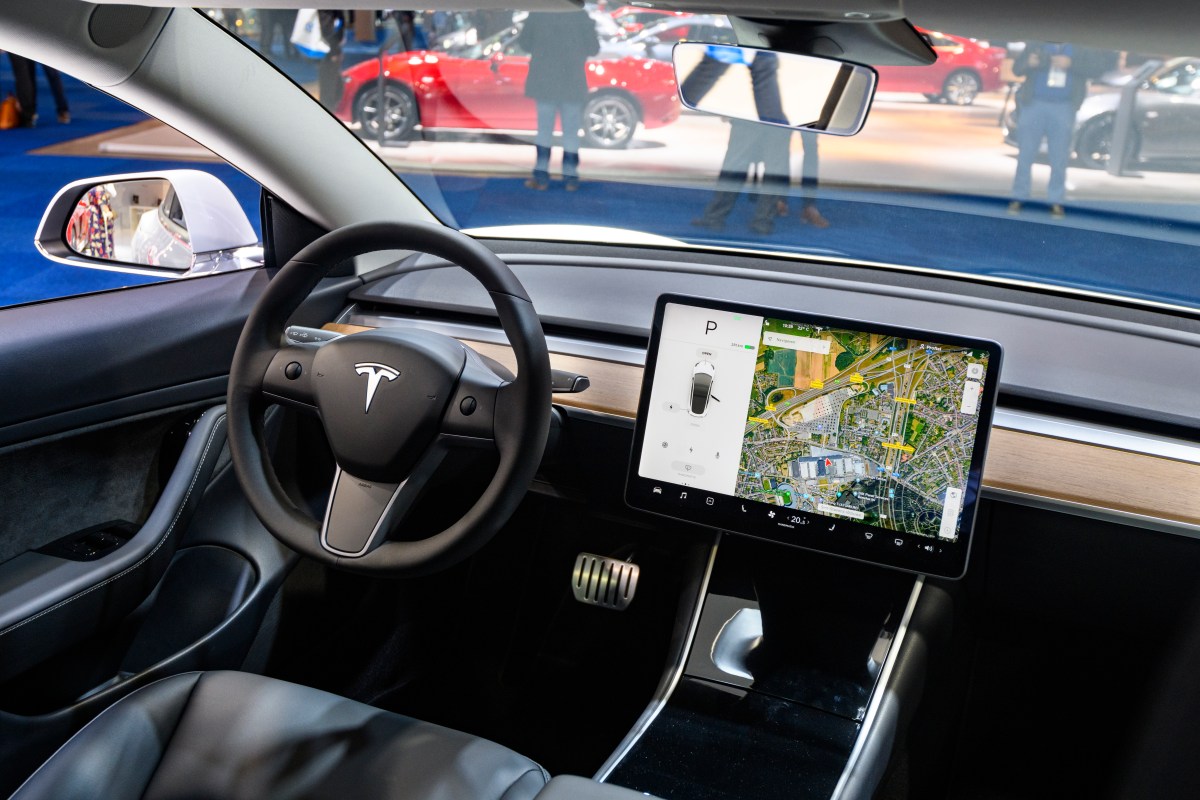 Tesla Model 3 compact full electric car interior with a large touch screen on the dashboard.