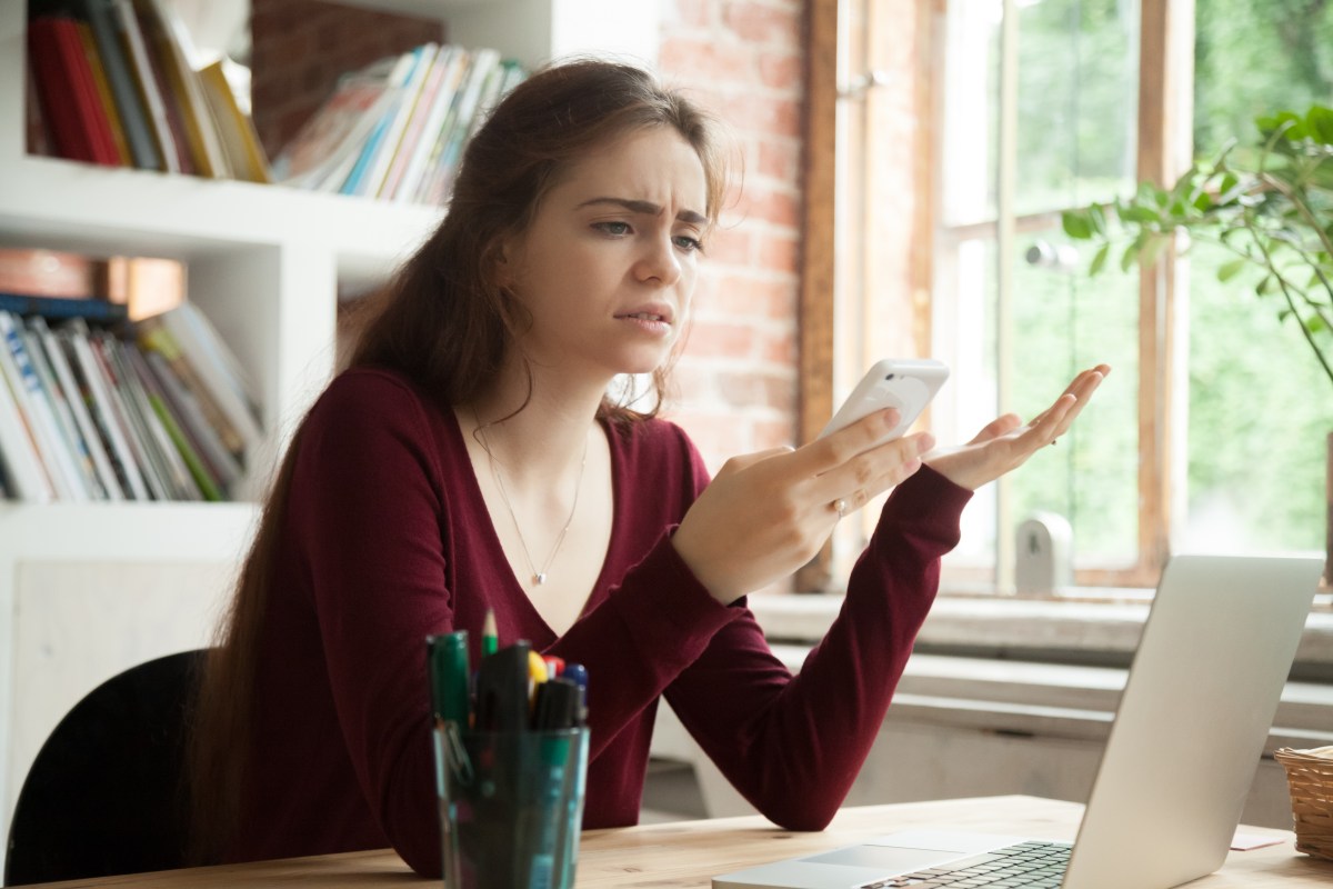 Annoyed frustrated woman having problem with not working mobile phone