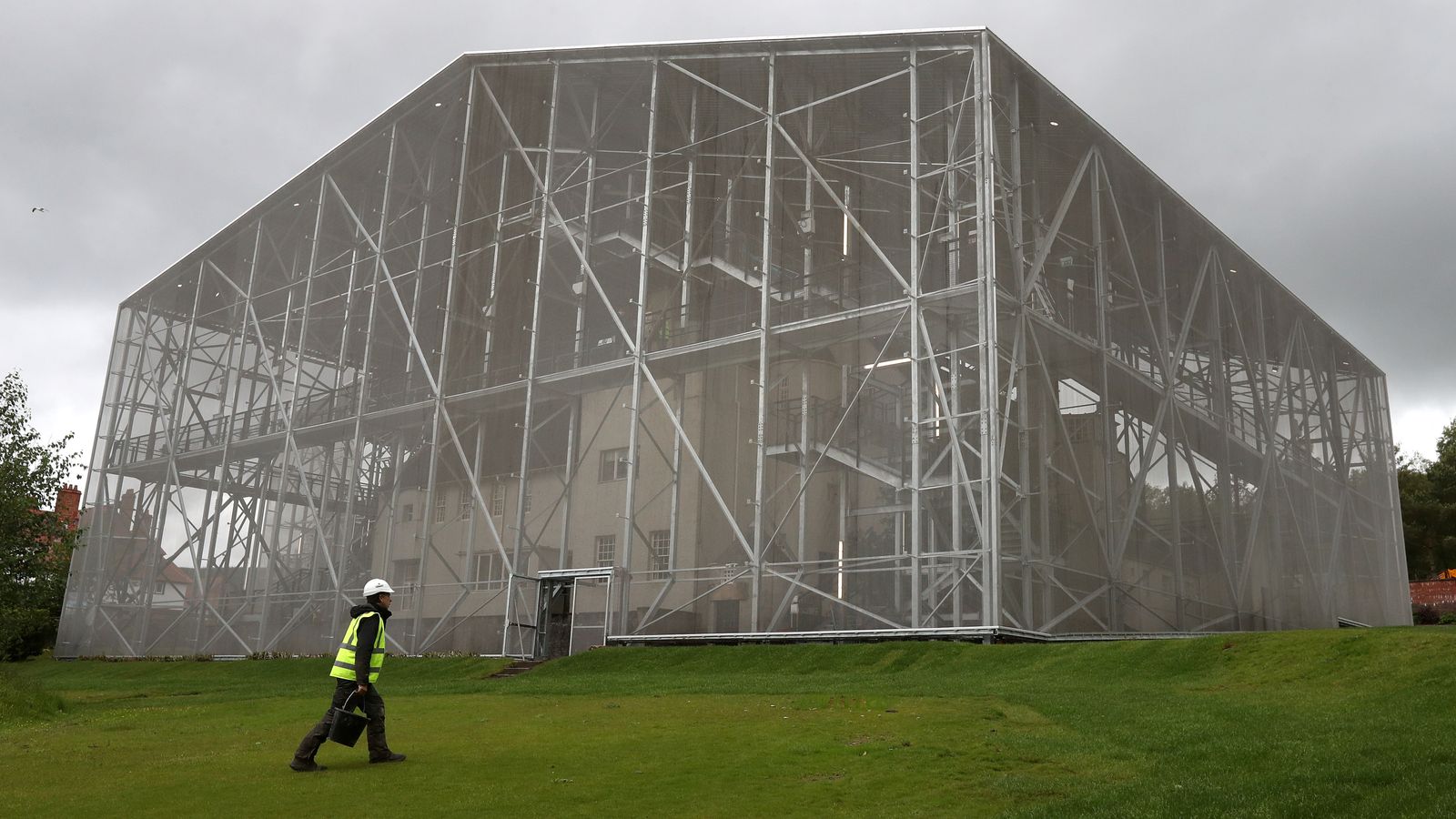 EMBARGOED TO 0001 THURSDAY DECEMBER 19 File photo dated 3/6/2019 of a gardener walks past the National Trust for Scotland's 'Box' which covers Charles Rennie Mackintosh's Hill House in Helensburgh. The steel box built to protect and dry out Charles Rennie Mackintosh masterpiece the Hill House will remain in place until 2028, the National Trust for Scotland (NTS) has announced. Issue date: Thursday December 19, 2024.