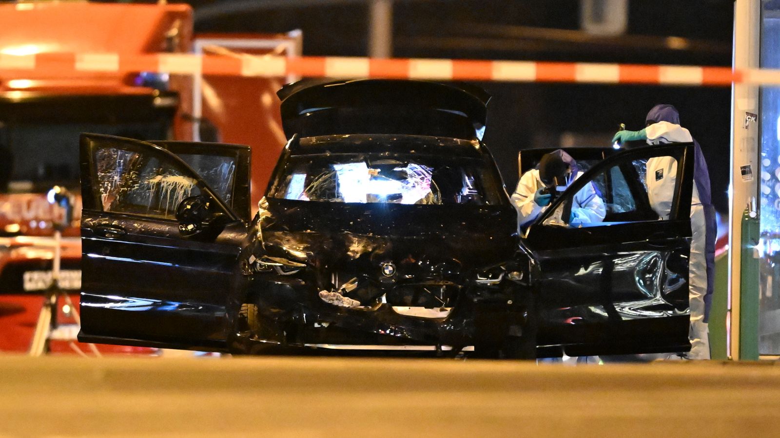 Forensic experts investigate a damaged car at the scene. Pic: Hendrik Schmidt/dpa via AP