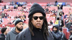 Musician Jay-Z stands on the field before an NFL football game between the Washington Commanders and Dallas Cowboys, Sunday, Nov. 24, 2024, in Landover, Md. (AP Photo/Nick Wass)