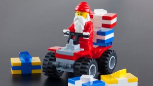 Tambov, Russian Federation - October 04, 2013 Lego Santa Claus minifigure on red quadrocycle with gift boxs on black background. Studio shot. LEGO is a popular line of construction toys manufactured by the Lego Group (Billund, Denmark).