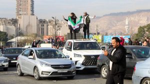 People holding a Syrian opposition flag celebrate in Damascus. Pic: Reuters