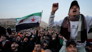 Syrian citizens wave the revolutionary flag and shout slogans as they celebrate during the second day of the take over of the city by the insurgents in Damascus, Syria, Monday, Dec. 9, 2024. (AP Photo/Hussein Malla)