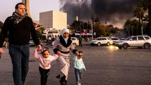 Smoke billows as people arrive to celebrate the fall of the Syrian government, in Damascus, Syria, Sunday, Dec. 8, 2024. (Ugur Yildirim/Dia Photo via AP)