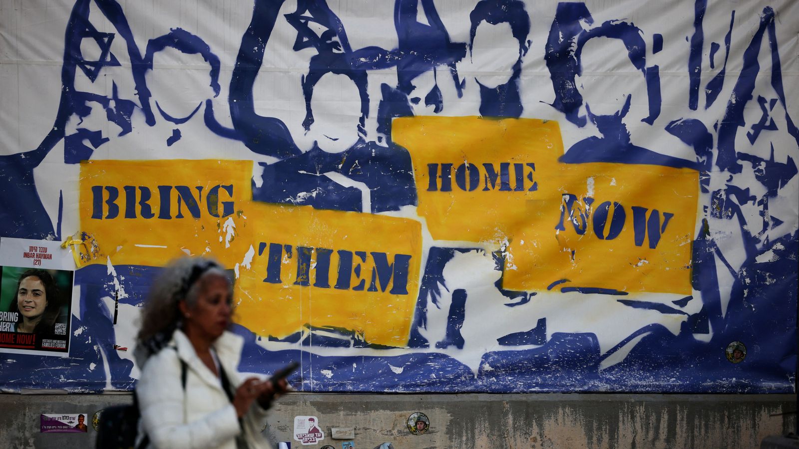 A woman walks past a poster calling for the release of the hostages kidnapped during the deadly October 7, 2023 attack by Hamas, amid the ongoing conflict in Gaza between Israel and Hamas, in Tel Aviv, Israel, December 5, 2024. REUTERS/Stoyan Nenov