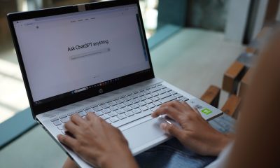 In this photo illustration, a woman browses OpenAI's website on her laptop