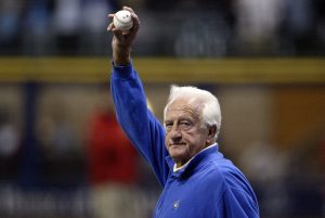 Former major league baseball player Bob Uecker waves to the fans as he walks out to mound to throw out the ceremonial first pitch prior to the Milwaukee Brewers playing against the Philadelphia Phillies in Game three of the NLDS during the 2008 MLB playoffs at Miller Park on October 4, 2008 in Milwaukee, Wisconsin.