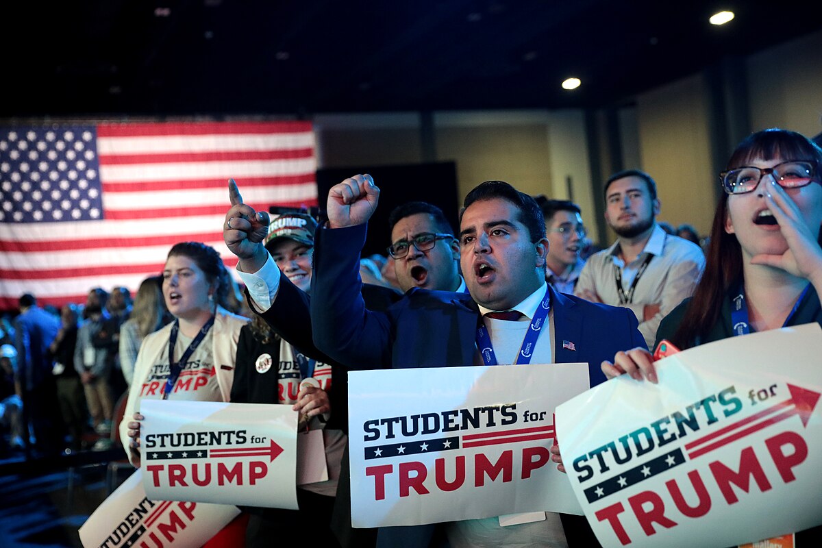 Students for Trump supporters during a political rally, with controversy surrounding meme coins in crypto markets.