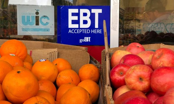 sign noting the acceptance of electronic benefit transfer (EBT) cards that are used by state welfare departments to issue benefits is displayed at a grocery store in 2019.