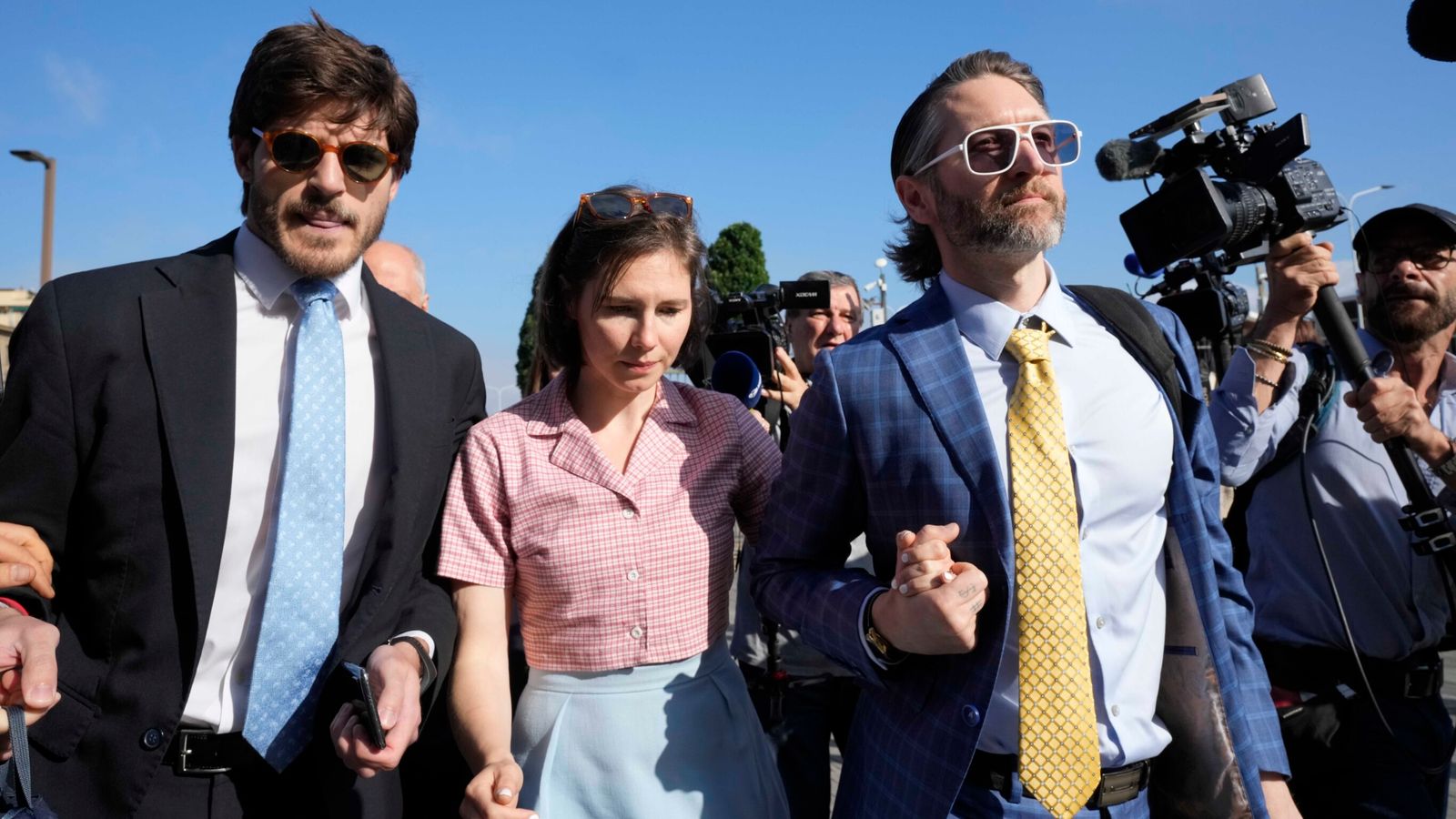 FILE - Amanda Knox arrives flanked by her husband Christopher Robinson, right, and her lawyer Luca Luparia Donati at the Florence courtroom in Florence, Italy, Wednesday, June 5, 2024. (AP Photo/Antonio Calanni, File)