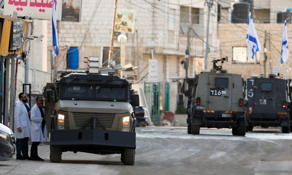 Israeli military vehicles drive on the street during an Israeli raid, in Jenin, in the Israeli-occupied West Bank, January 21, 2025. REUTERS/Raneen Sawafta