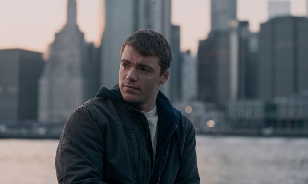 Peter looks to the side with the city skyline behind him in The Night Agent season 2