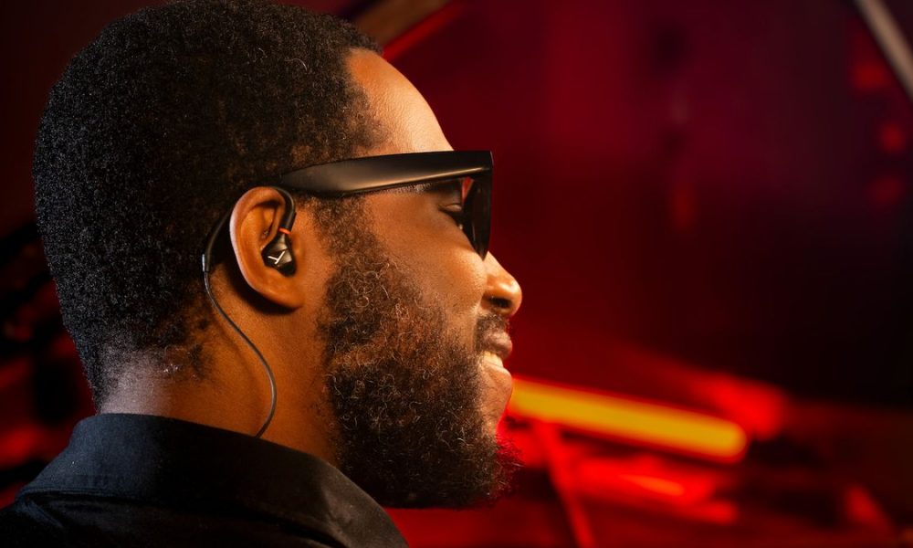 Cory Henry wearing Beyerdynamic's new pro-specific IEMs, sitting at a piano