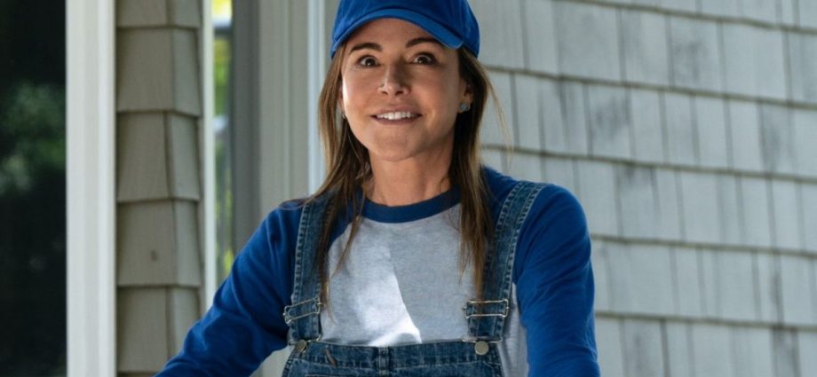 Christa Miller smiling while wearing a baseball cap in Shrinking.