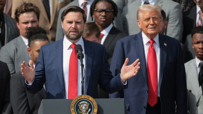 JD Vance is speaking at a podium while Donald Trump looks on during a ceremony on the south lawn of the White House