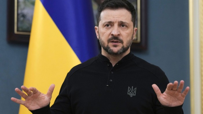 Volodymyr Zelenskyy in front of a Ukrainian flag