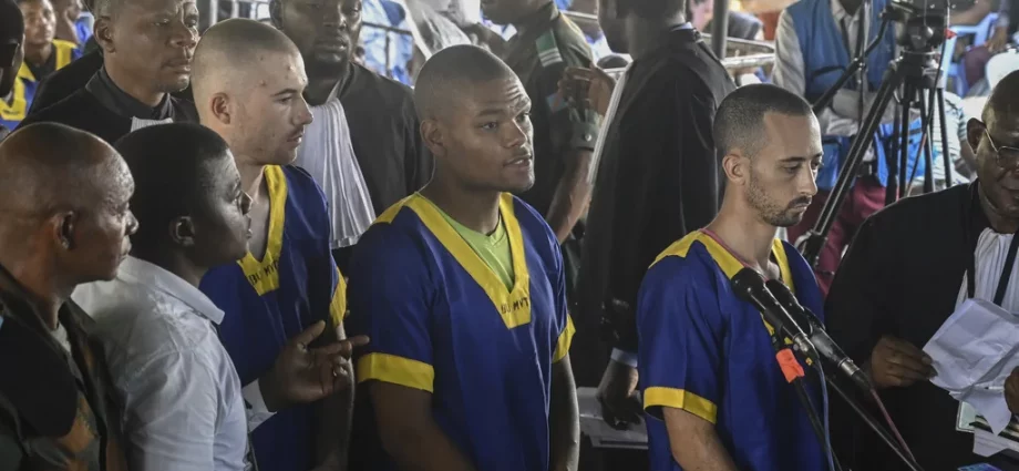 Tyler Thompson Jr., Marcel Malanga and Benjamin Reuben Zalman-Polun, all American citizens, face the court in Kinshasa, Congo, with 52 other defendants, June 7, 2024, accused of a role in the attempted coup in Congo led by little-known opposition figure Christian Malanga in which six people were killed.