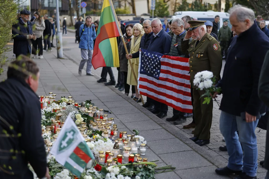 People with U.S. national flag come to pay their last respect to the three soldiers found dead on Monday at a training range in Pabrade, near the U.S. Embassy in Vilnius, Lithuania, Tuesday, April 1, 2025.