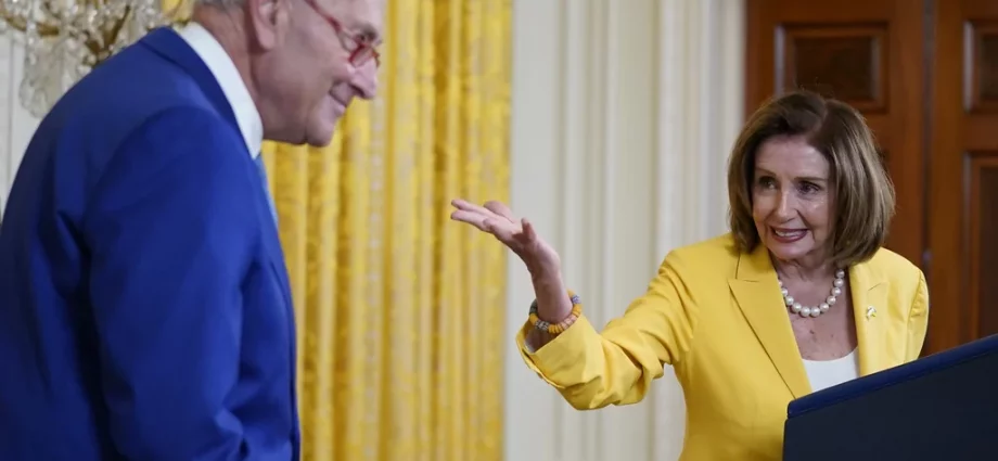 Former Speaker of the House Nancy Pelosi, D-Calif., looks to Senate Majority Leader Chuck Schumer, D-N.Y., as she speaks on the anniversary of the Inflation Reduction Act during an event in the East Room of the White House, Wednesday, Aug. 16, 2023, in Washington. (AP Photo/Evan Vucci)