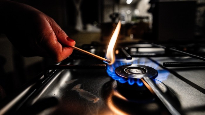 Close-up of a resident’s hand lighting a gas stove