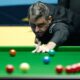 Snooker player Ronnie O&#039;Sullivan takes a shot, with red, yellow, green, brown and blue balls visible