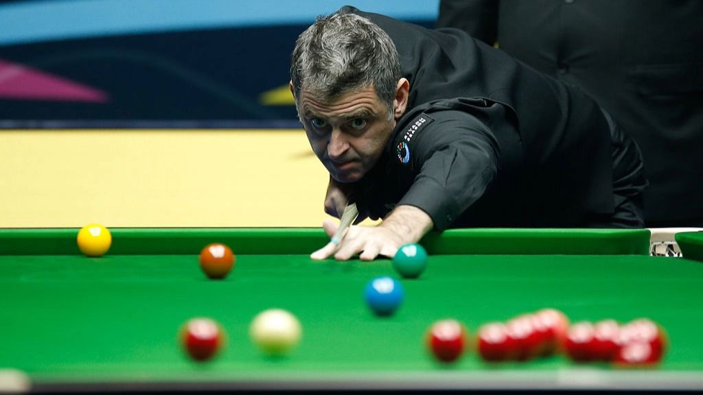 Snooker player Ronnie O&#039;Sullivan takes a shot, with red, yellow, green, brown and blue balls visible