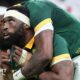 South Africa captain Siya Kolisi looks and points upwards as he is hugged by a team-mate