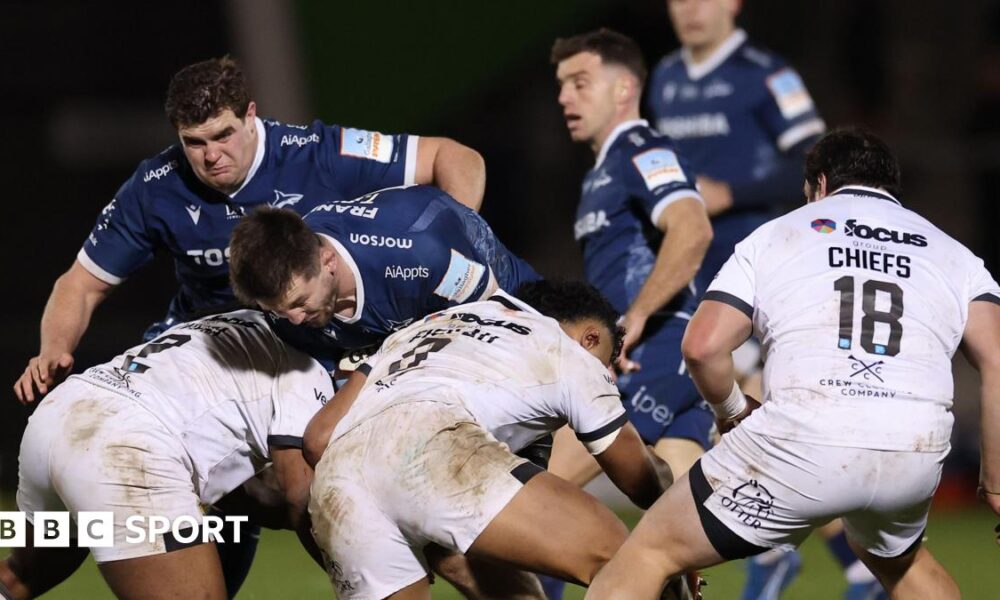 Tom Curry of Sale runs into three Exeter defenders