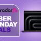 A MacBook Pro against a purple TechRadar Cyber Monday deals background
